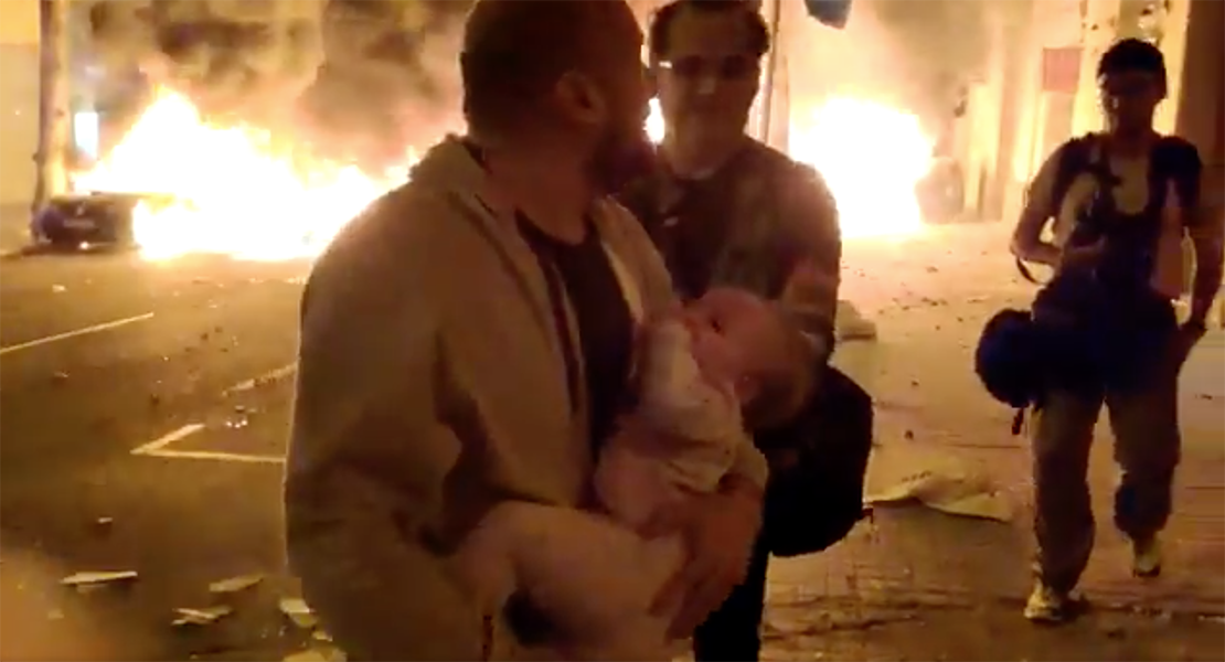 Un padre huye de su casa con su bebé tras un fuego provocado en las protestas de Barcelona